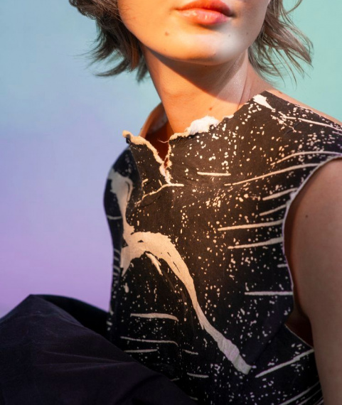 Blurry image close up of girl's chest wearing a black and white zebra print artistic top made by Filippa Fuxe