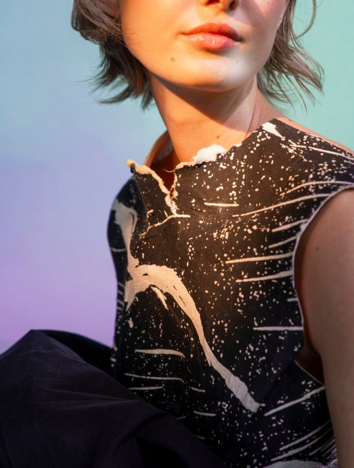 Blurry image close up of girl's chest wearing a black and white zebra print artistic top made by Filippa Fuxe