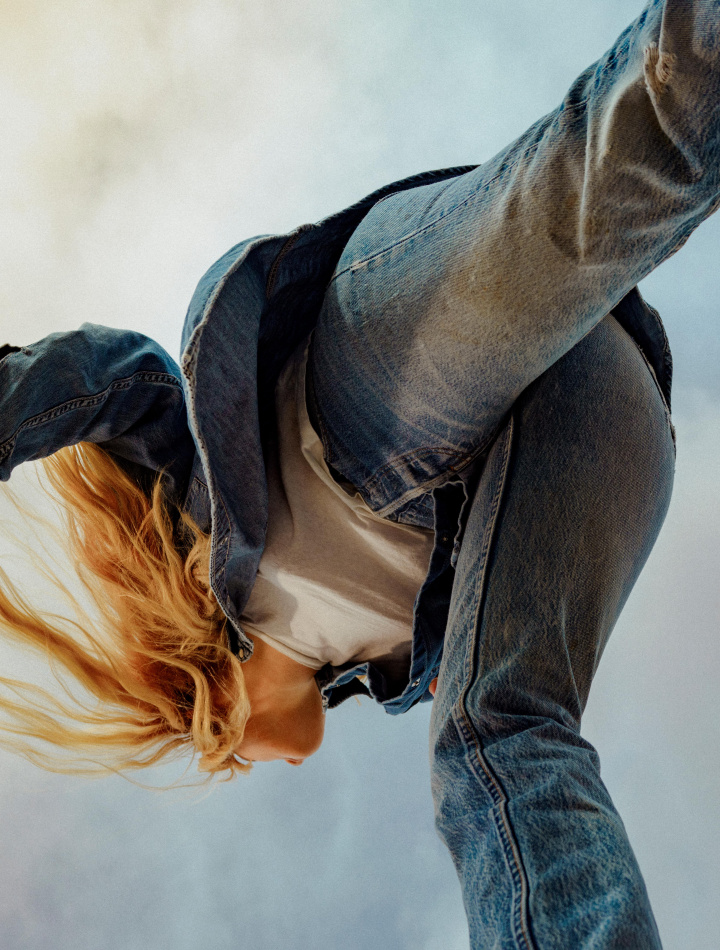 Girl wearing levi's 501 denim made with circulose walking in dusky blue sky background