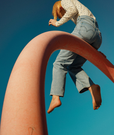 girl wearing levi's denim sitting on a high beam